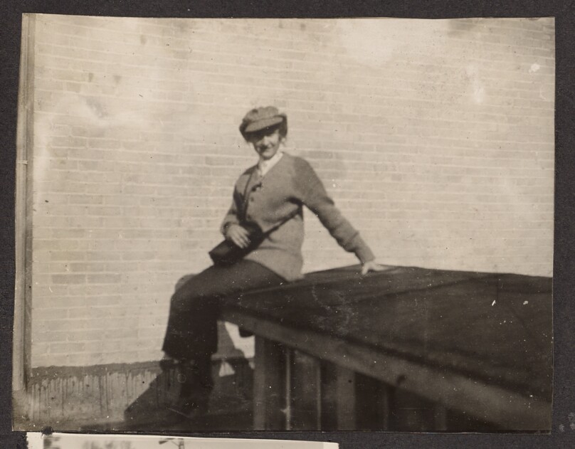 [Woman sitting in front of a brick wall]