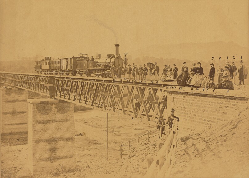 [Group portrait with train on bridge]