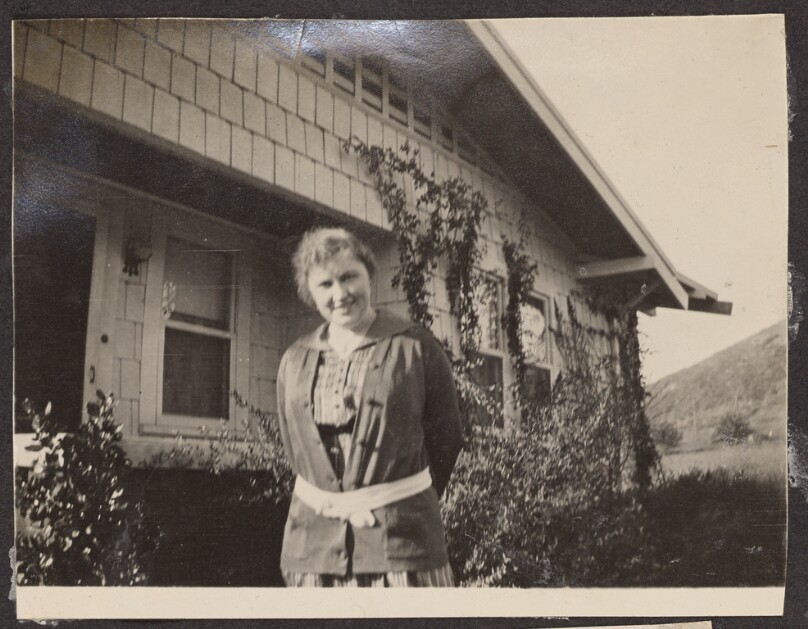 [Woman posing in front of a house]