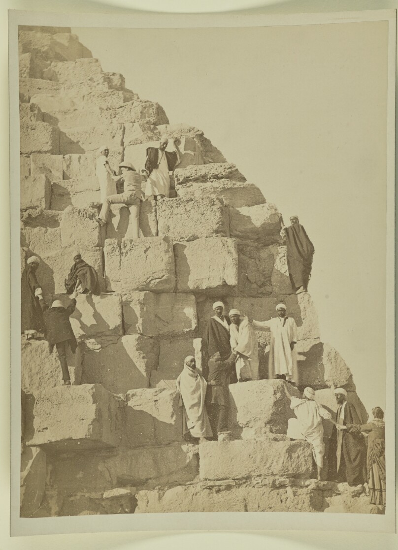[Men standing on steps of pyramid]