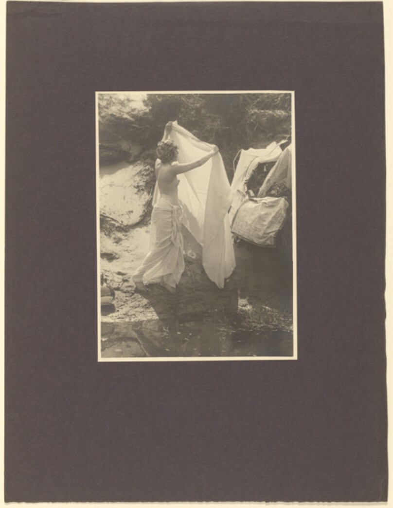 [Draped female nude hanging laundry]