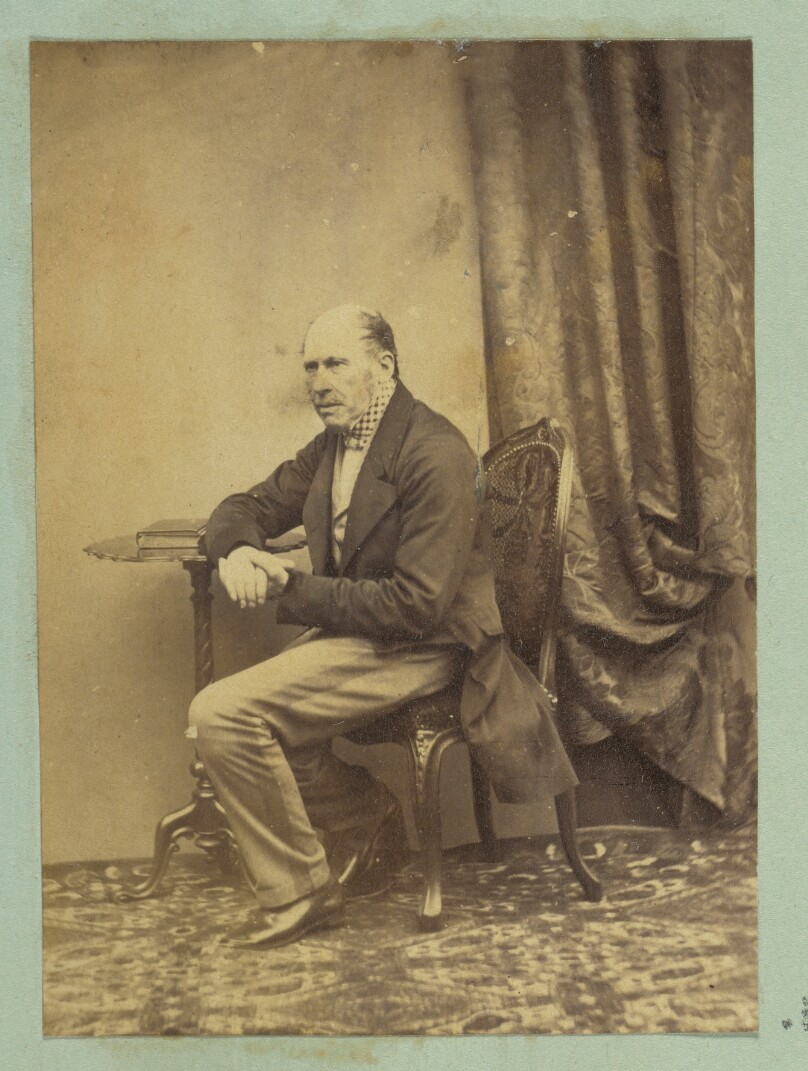 [Portrait of seated man leaning on table]