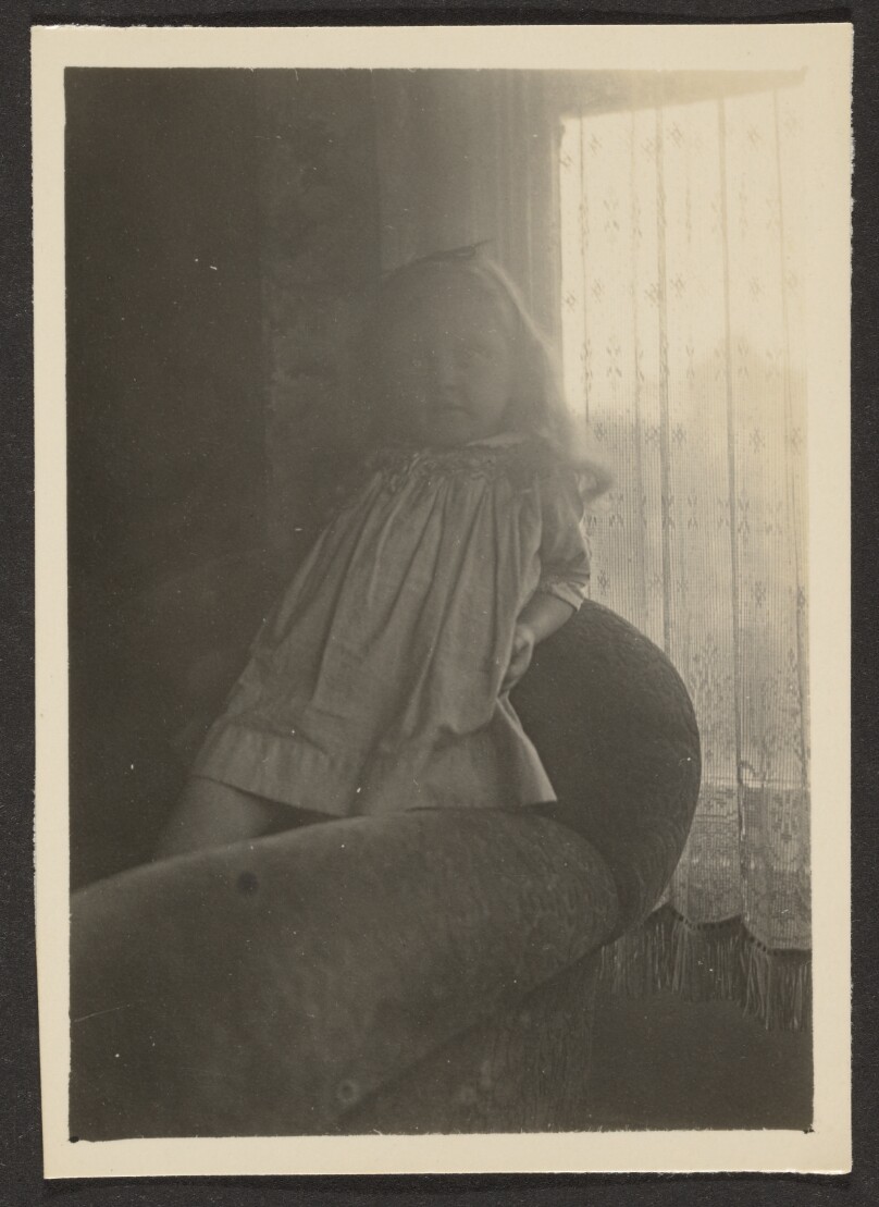 [Little Girl Leaning on Chair Back]