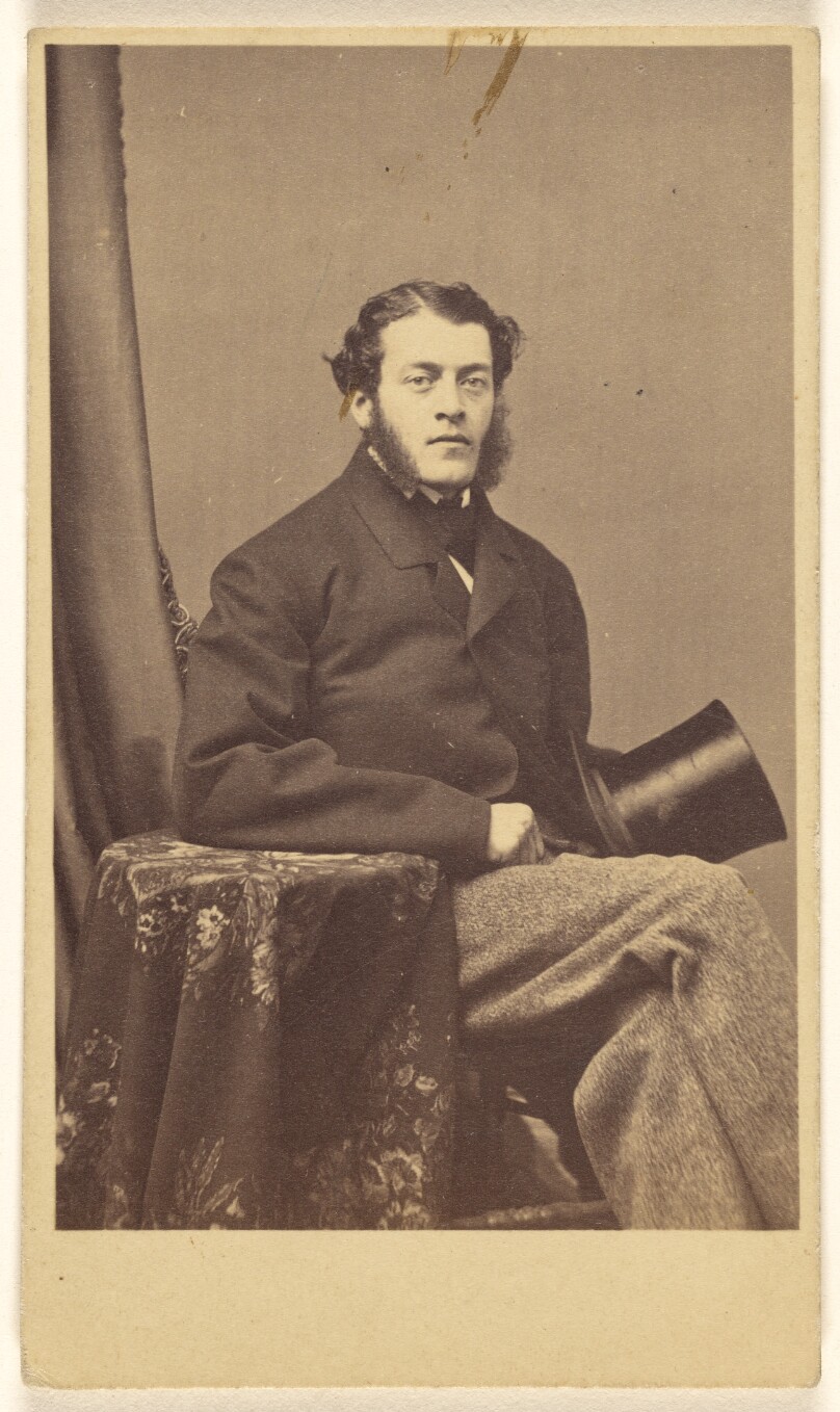 [Unidentified man with muttonchops seated, holding a top hat]
