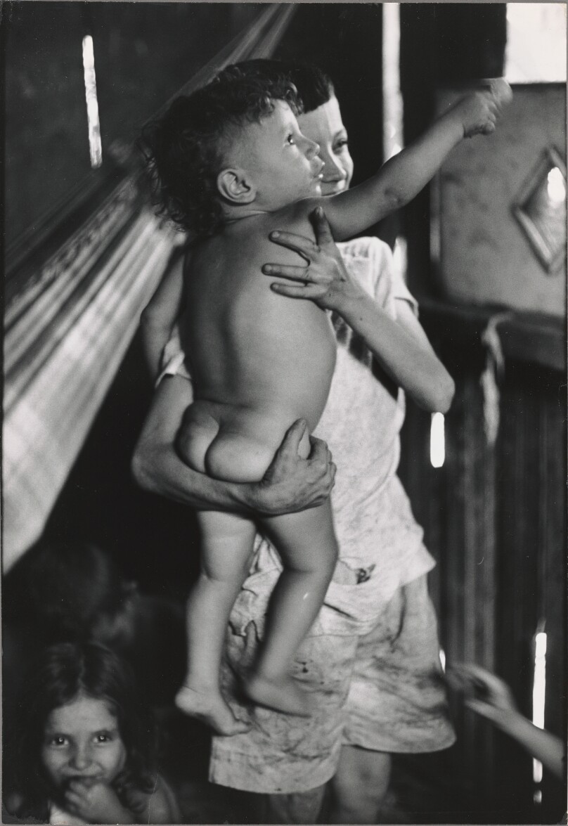 Flavio da Silva holding his brother Zacharias watching a spider, Brazil