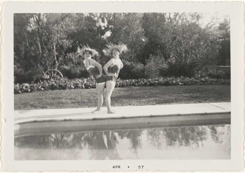 [Two women posing by pool]