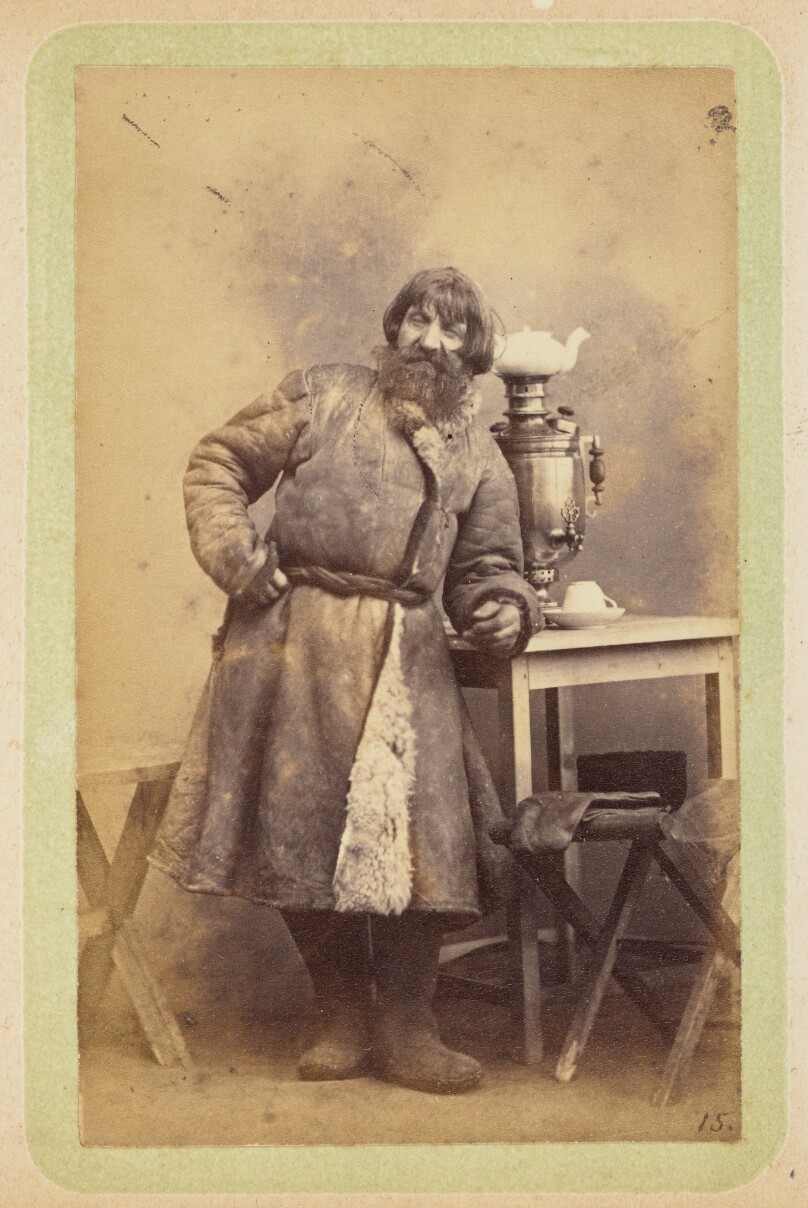 [Man in coat leaning on table]