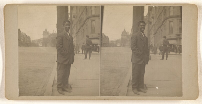 [Black man posed on street at light pole, Albany, N.Y.]