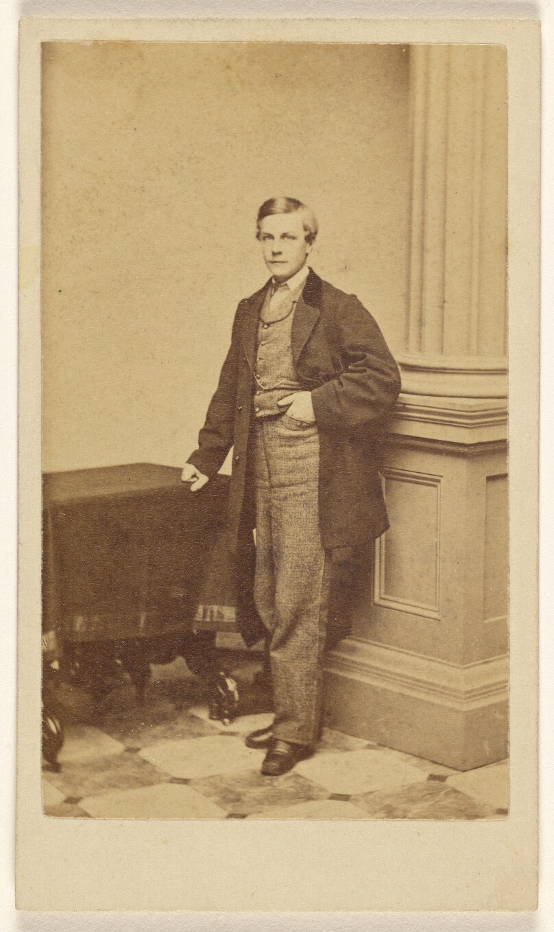 [Unidentified young man standing with hand in his pocket]