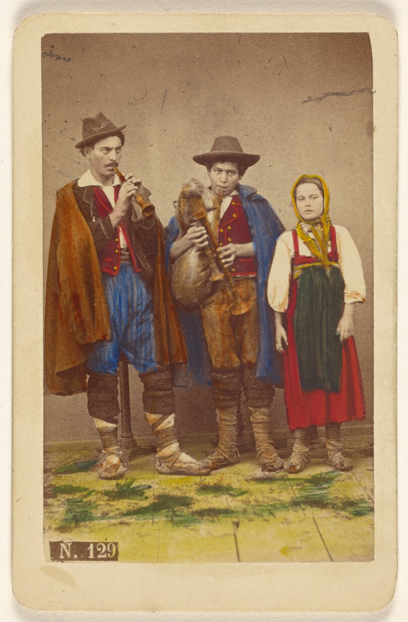 [Three Italian peasants standing: two men playing wind instruments, a girl next to them]
