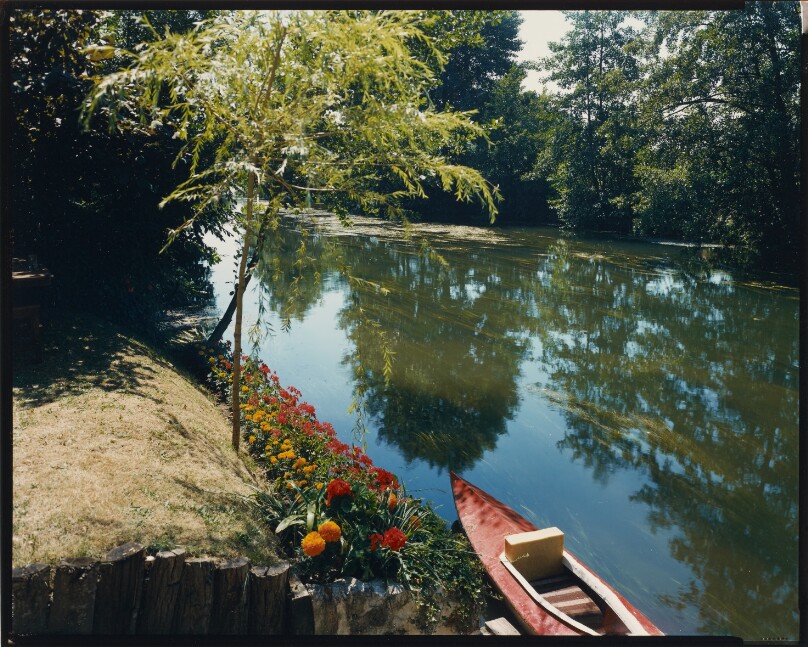 [Red boat docked along River Huisne]