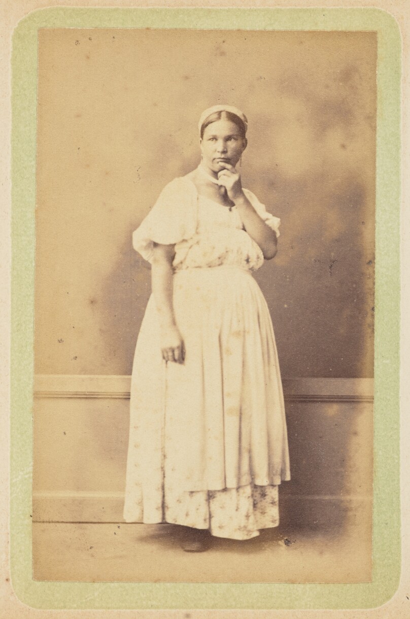 [Woman posing in apron and bonnet]