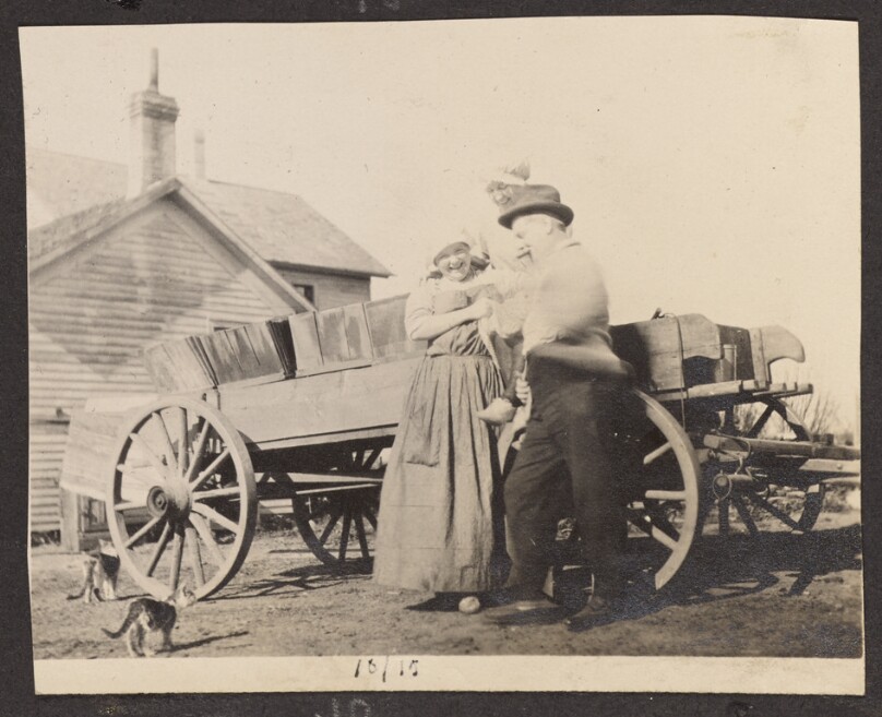 [Man and women in front of a cart]