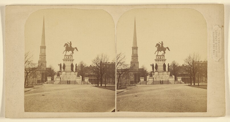 [View of town square with statue of man on horse at center]