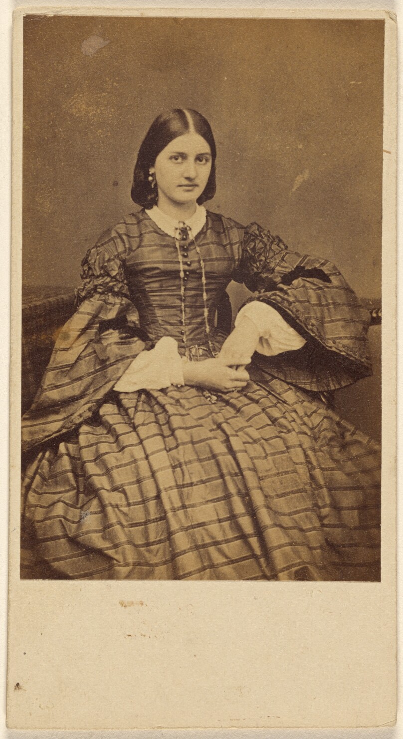 [Young woman in striped dress, seated]