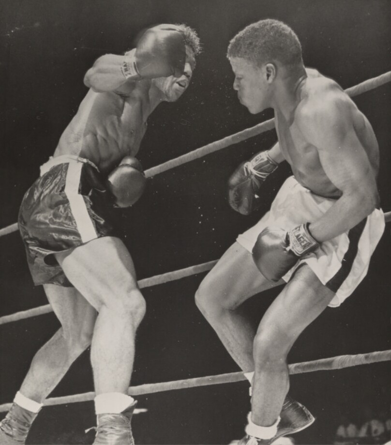 [Two boxers fighting in a ring]