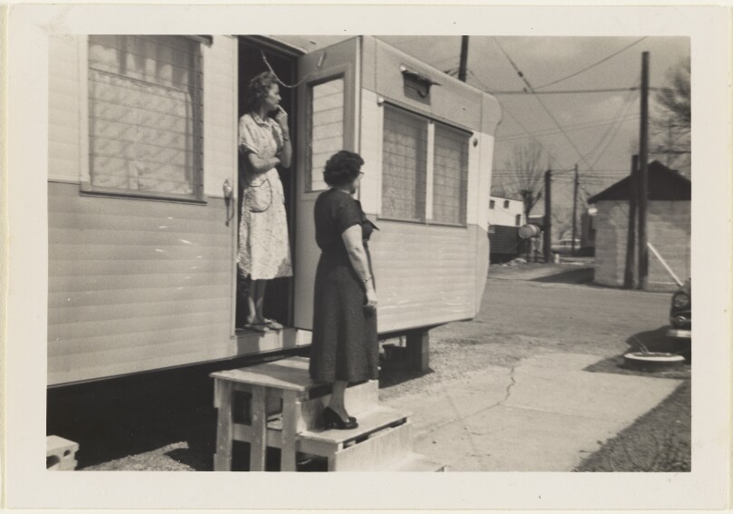 [Two women at door of trailer]