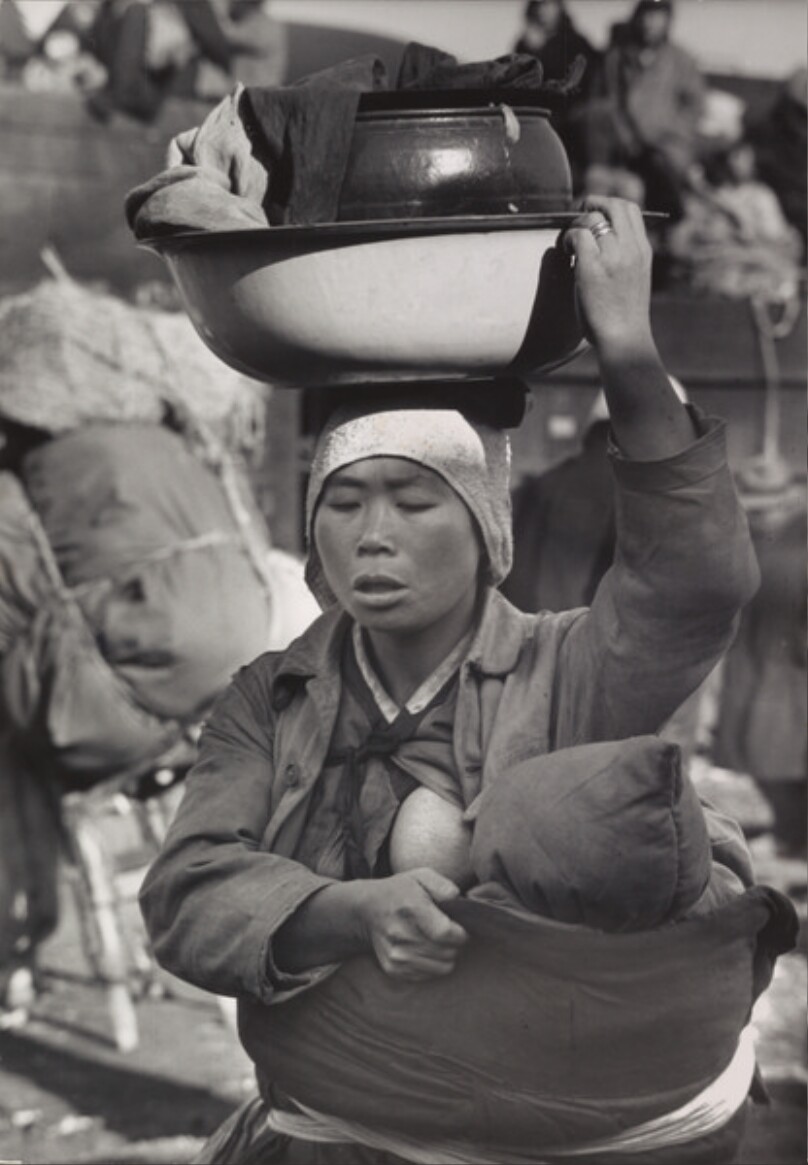 A Korean mother carrying her baby and worldly goods flees the fighting around Seoul