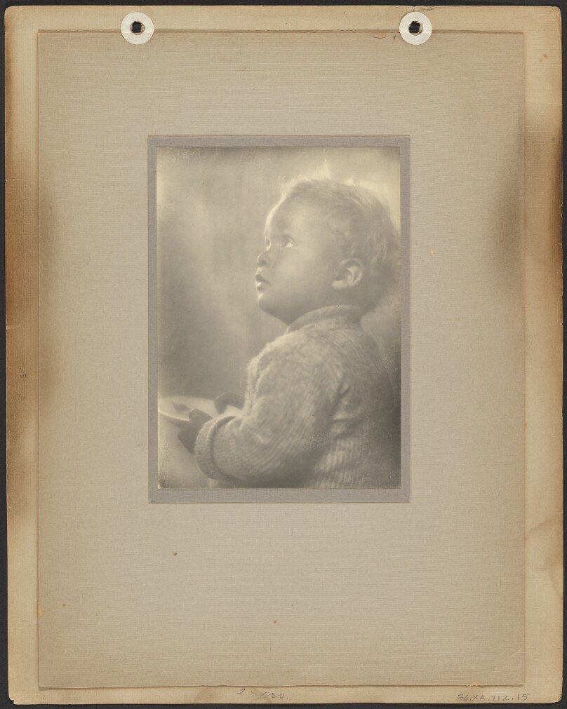 [Brett Weston in sweater, looking up, holding plate with flag]