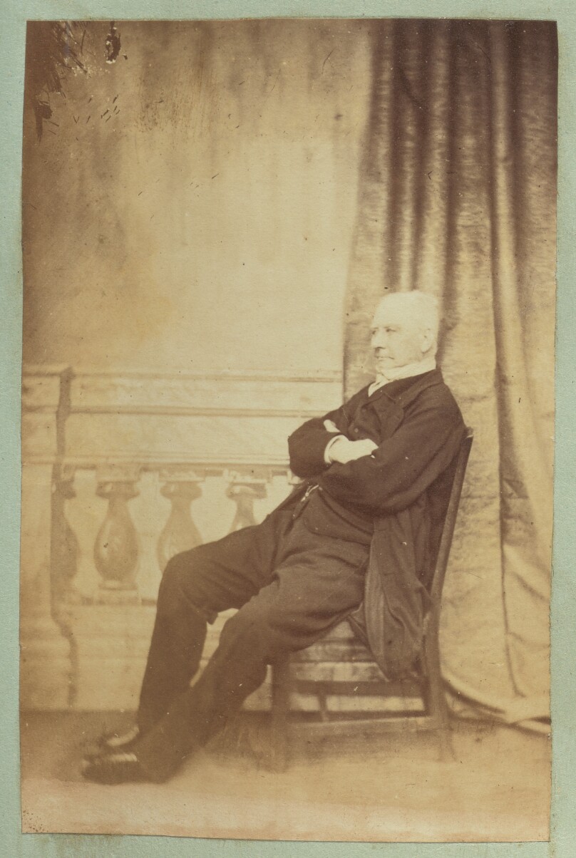 [Portrait of man with studio background of baluster and curtain]