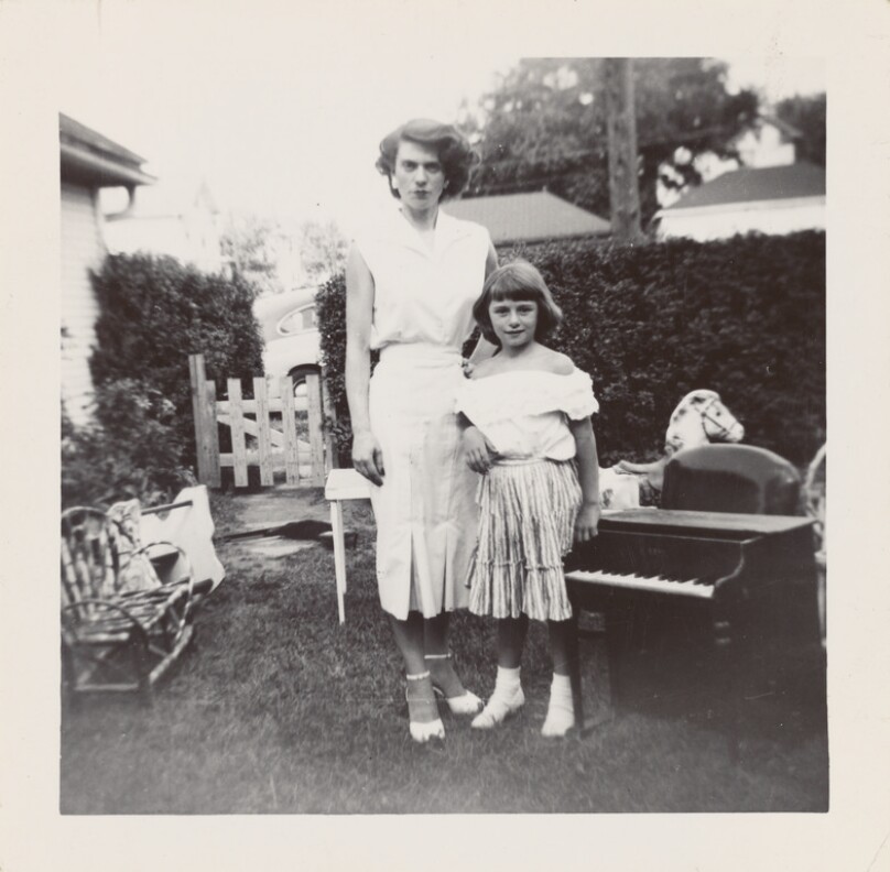 [Woman with young girl in yard]