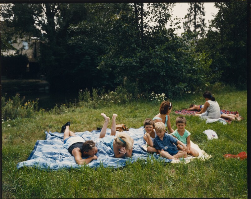 [People resting on blankets in grass]