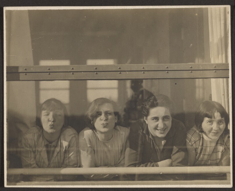 [Four Women Looking Through Window]