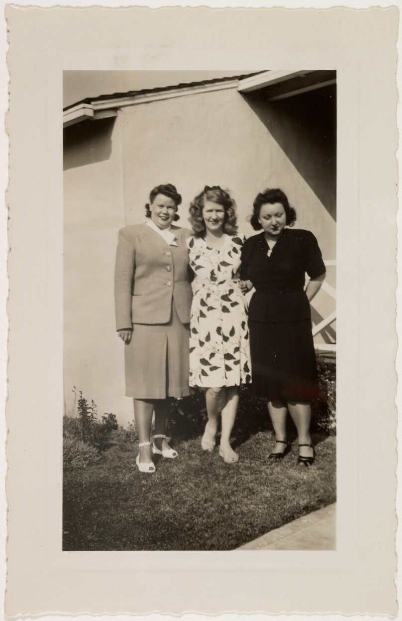 [Three women in front of house]