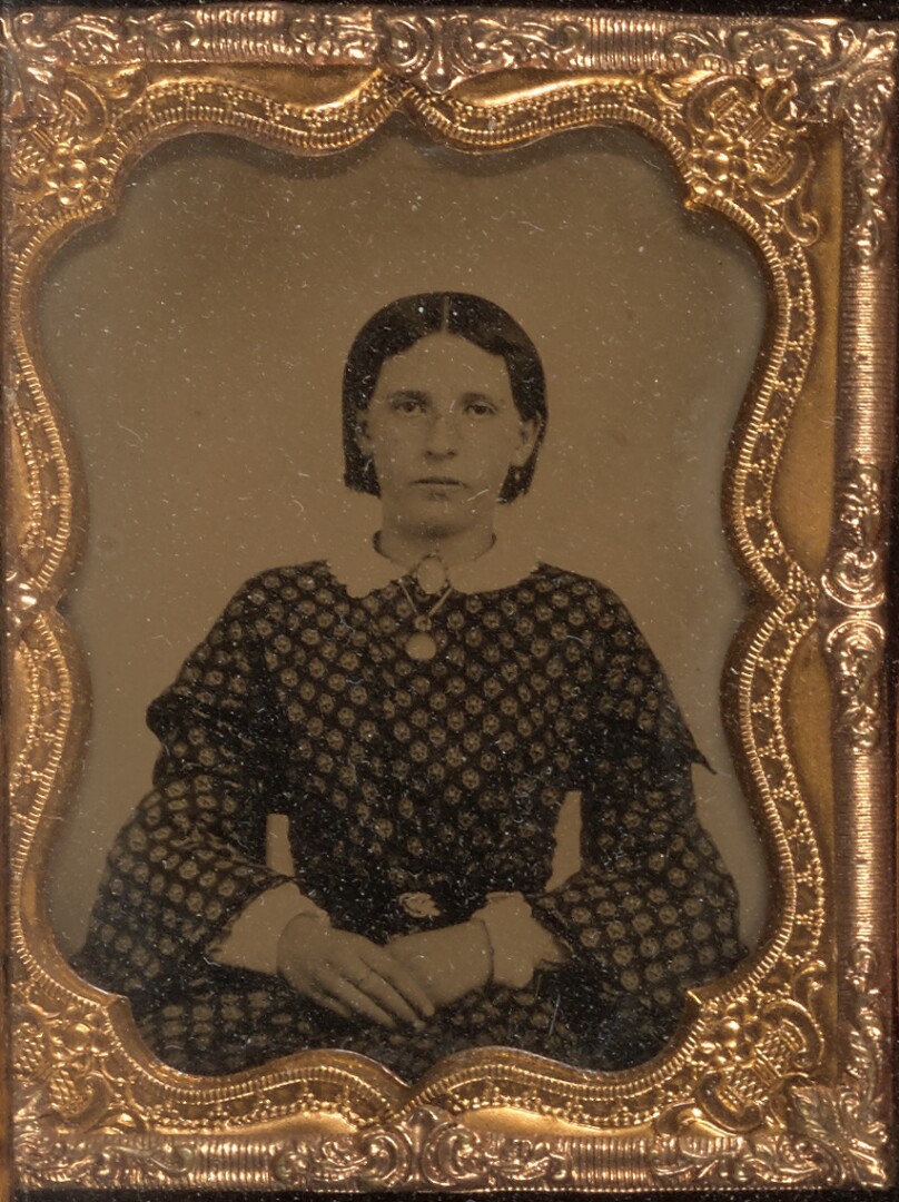 [Young woman seated wearing a cameo and locket]