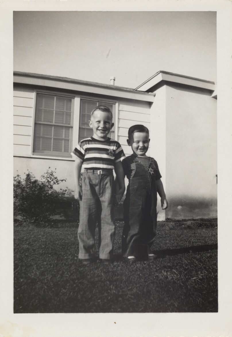 [Two boys wearing sheriff badges]