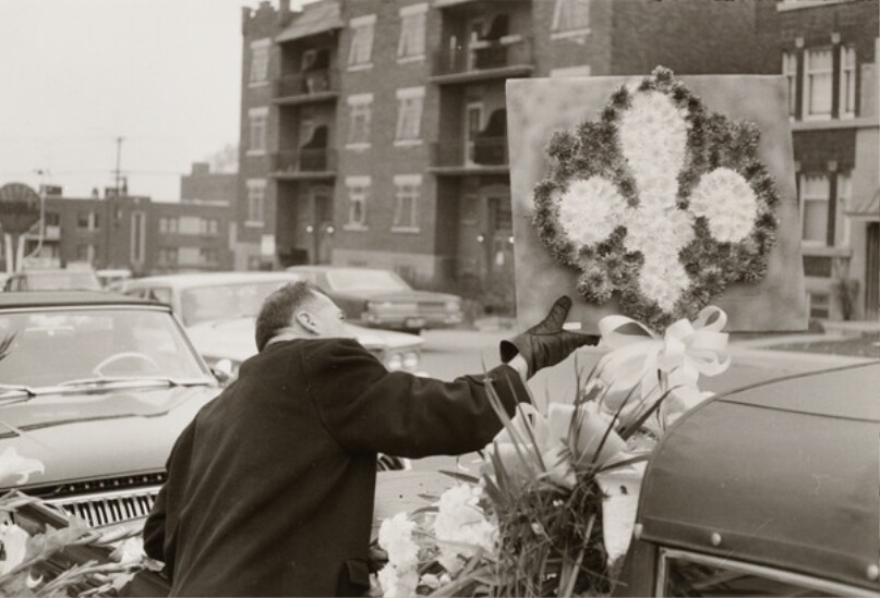 [Man adjusting funeral flowers]