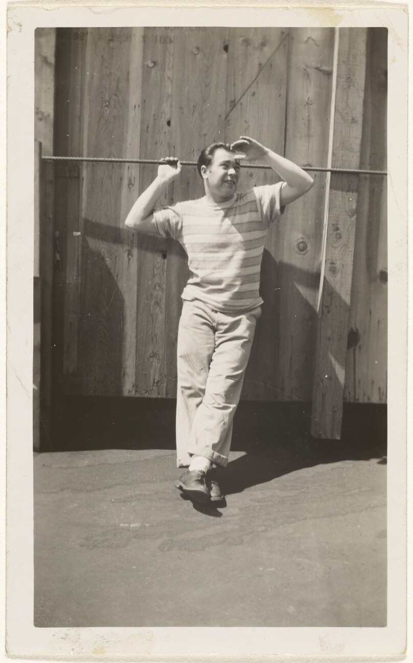 [Man leaning on fence]