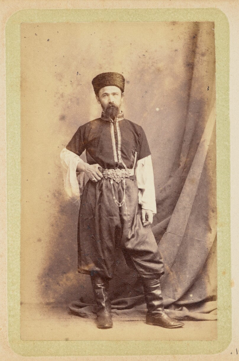 [Man posing in tunic and wide pants]