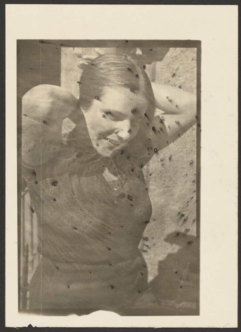 [Female pulling back hair - photomontage (?) with sand granules (?)]
