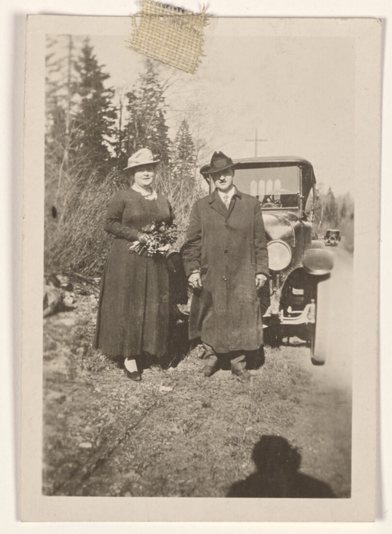 [Man and woman pose with a car]