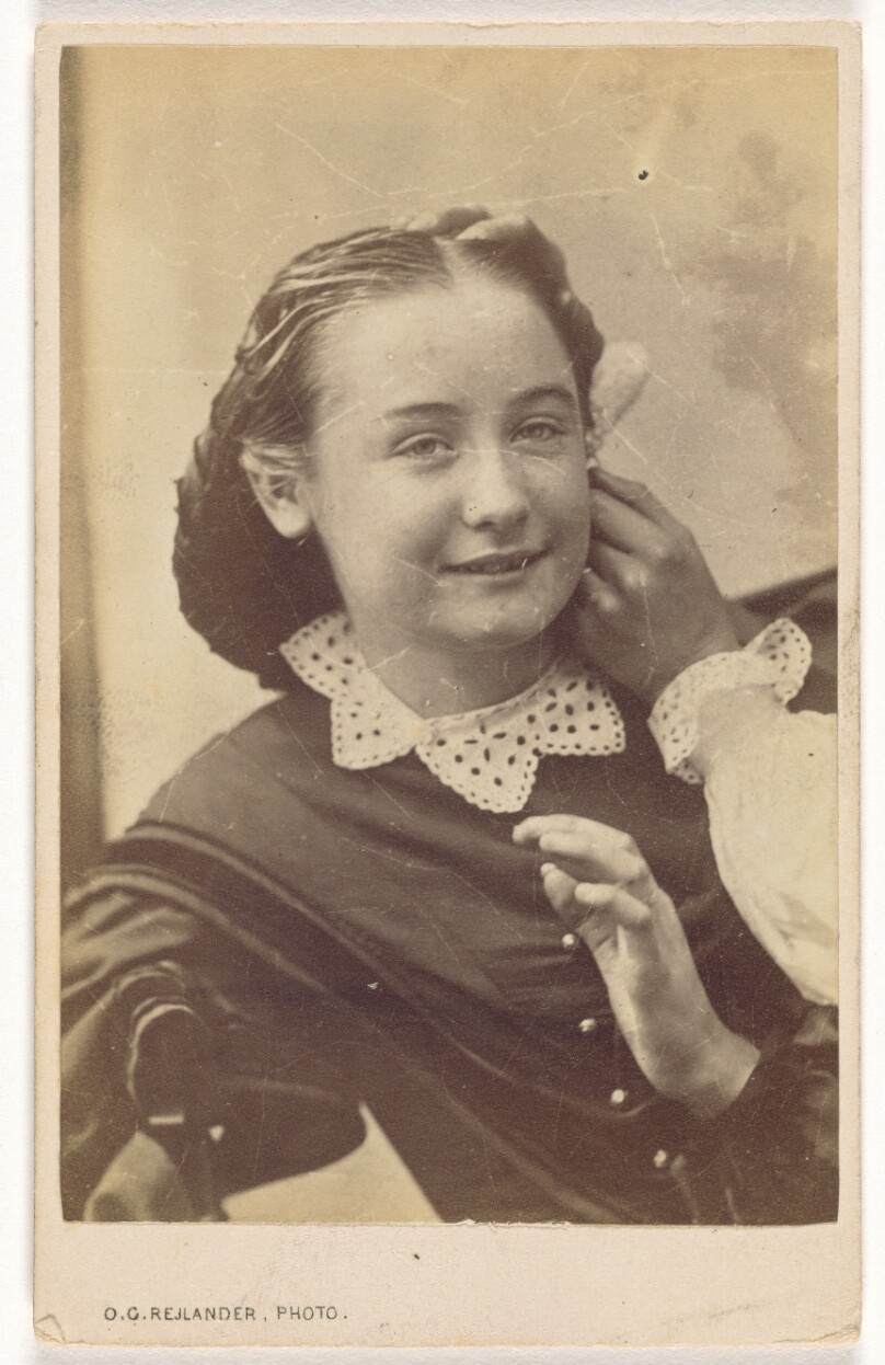 [Seated Young Girl With an Unknown Hand Touching the Side of Her Face]