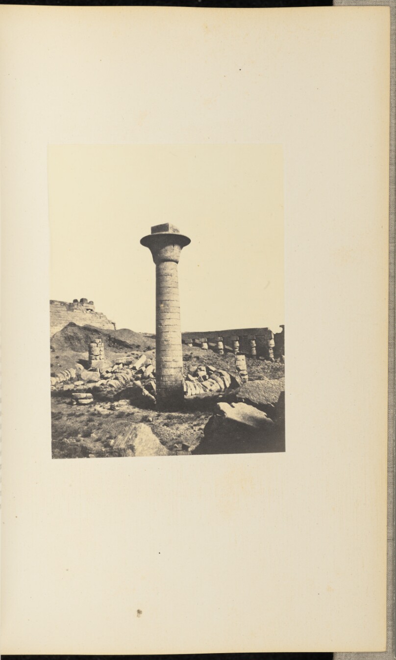 [Stone column standing among ruins]