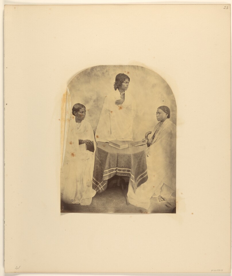 [Group portrait around a table]