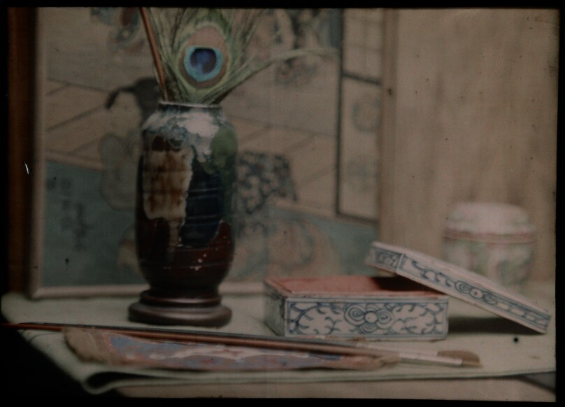 [Vase with peacock feather, lacquered box and paint brushes]