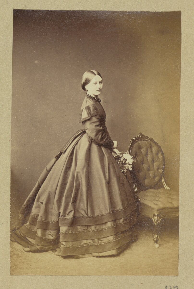 [Portrait of woman wearing high-collared dress]