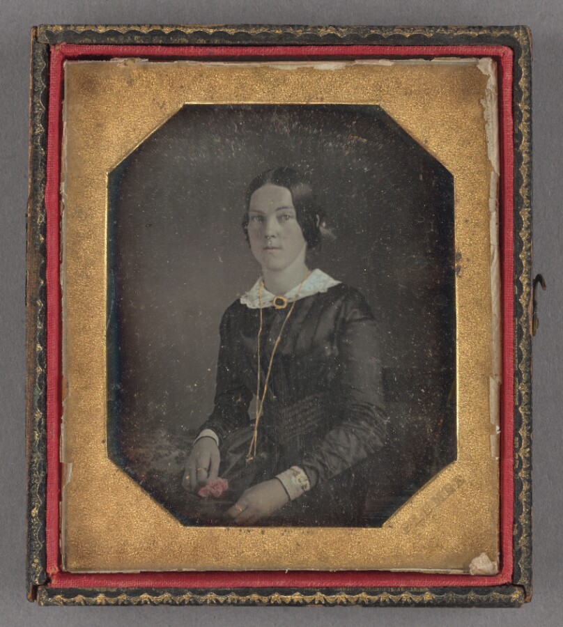 [Portrait of a young woman holding a flower]