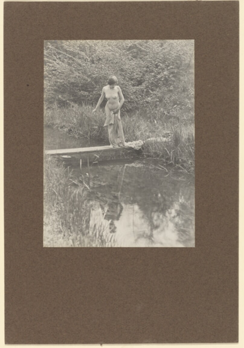 [Female nude standing over river]