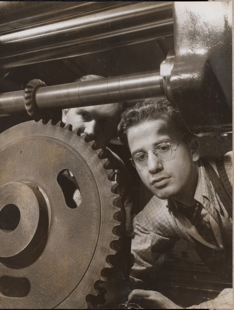[Close-up of a man working with a large gear]