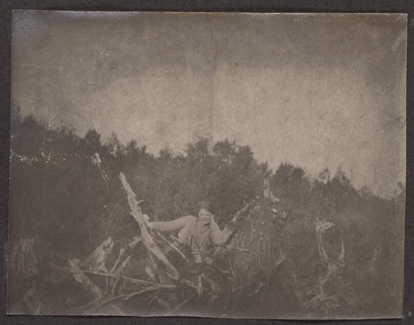 [Woman leaning against tree branches]