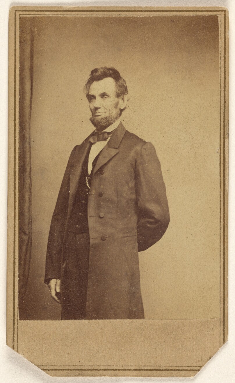 [Abraham Lincoln standing with one arm behind his back]
