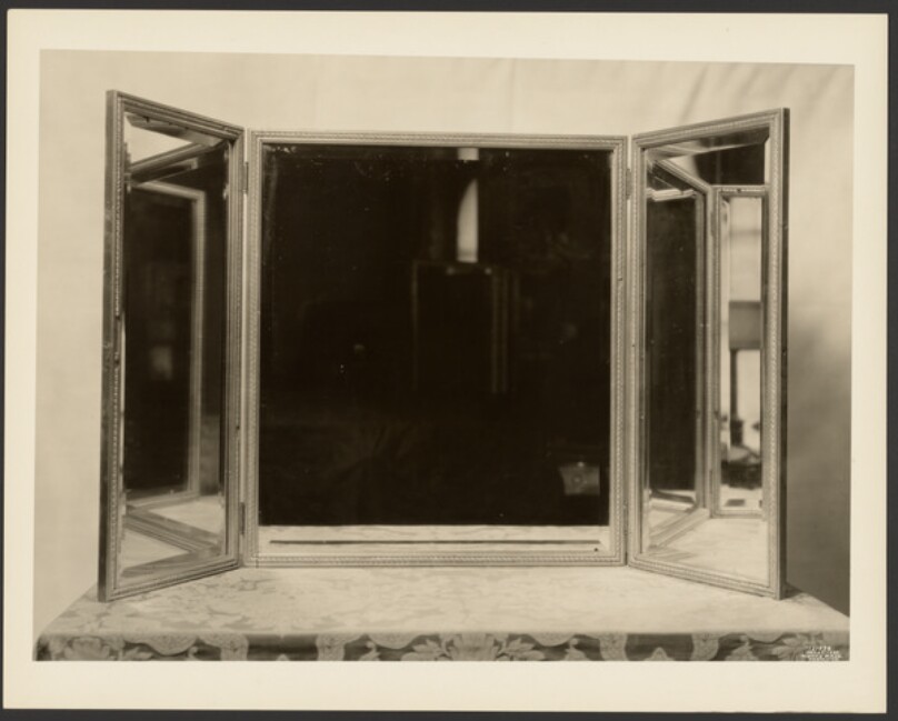 [Three part mirror on table]