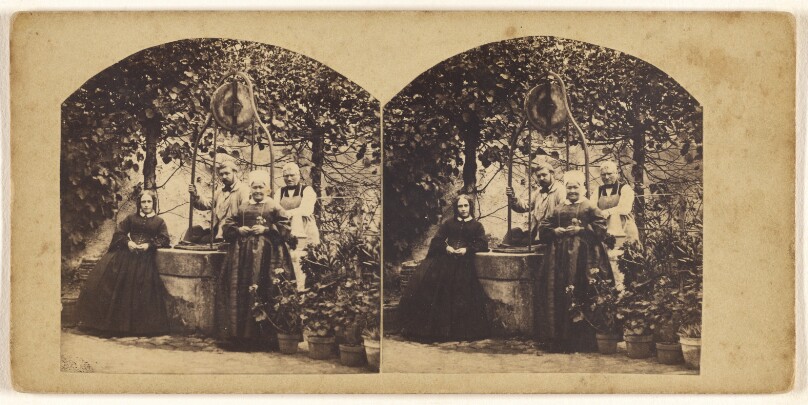 [Young French couple and two elders standing in their garden near a well]