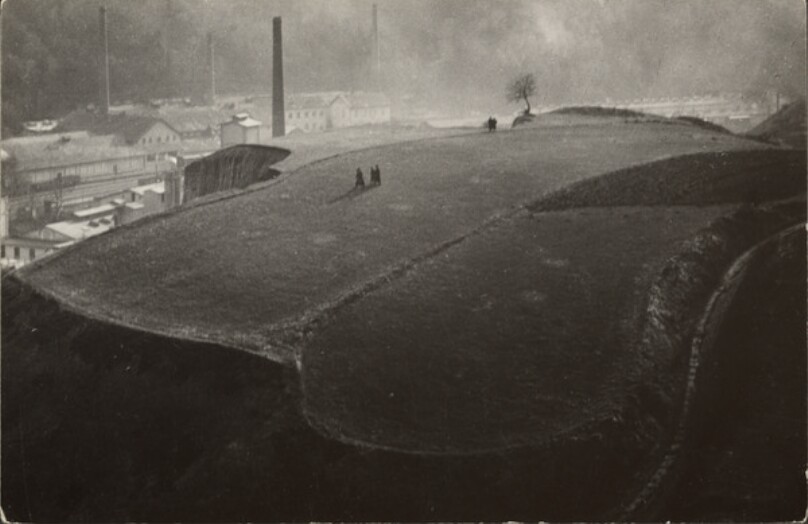 [Hill above industrial city]