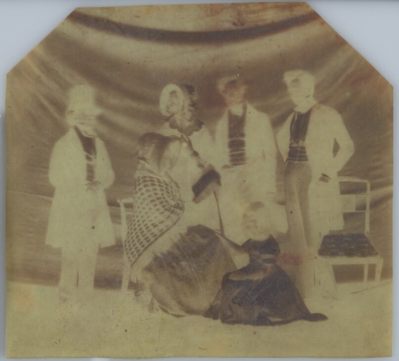 [A Group Poses in Front of a Backdrop]
