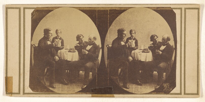 [Three men and a small boy seated at a table, drinking]